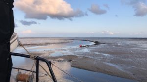 Met het zeilschip klipper nova cura droogvallenn in de haven van Schiermonnikoog met prachtig uitzicht op Groningse kust