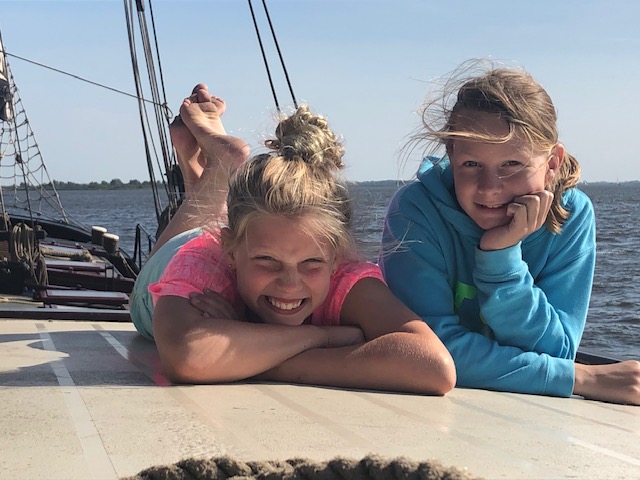 kinderen aan dek genieten in de zon klipper nova cura zeilschip op de waddenzee